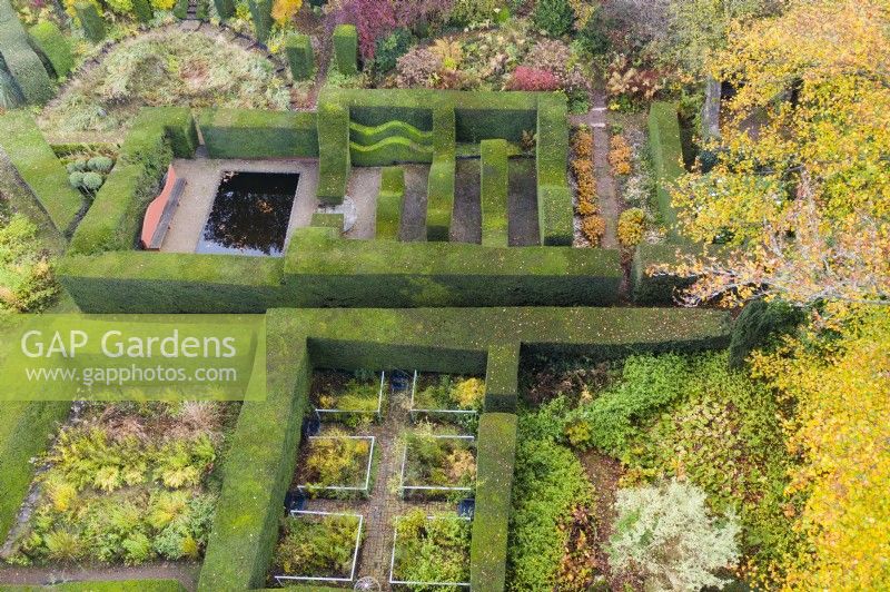 View over mature clipped hedges of Yew containing several distinct garden rooms; image taken with drone. November. Autumn.