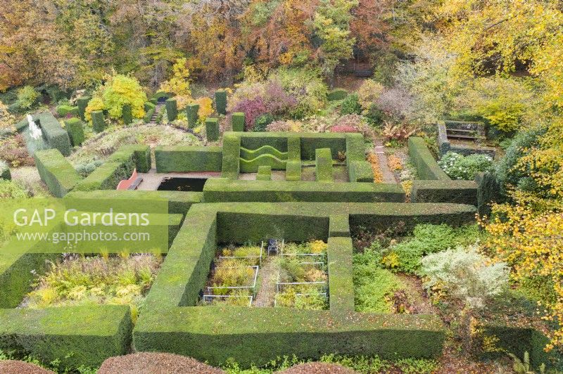 View over mature hedges of clipped Yew defining several garden rooms; image taken with drone. November. Autumn.