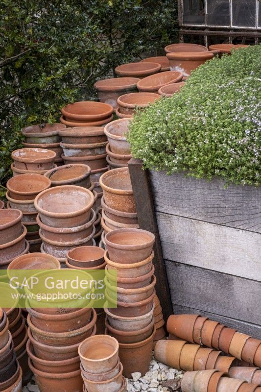 Stacked terracotta pots in work area of garden