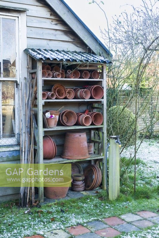 Home made shelving rack for storing collection of vintage terracotta flowerpots.