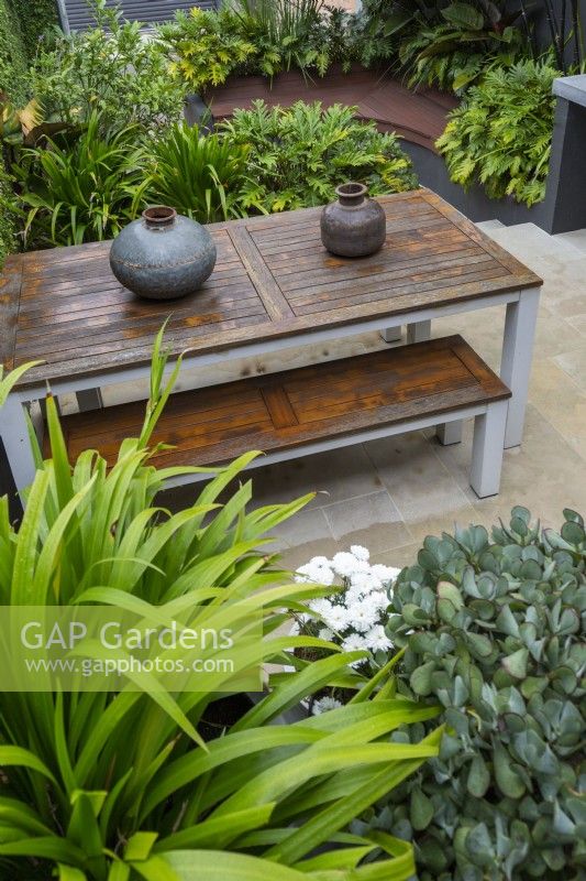 Overhead view of an outdoor table and bench seat with decorative hand made metal pots.