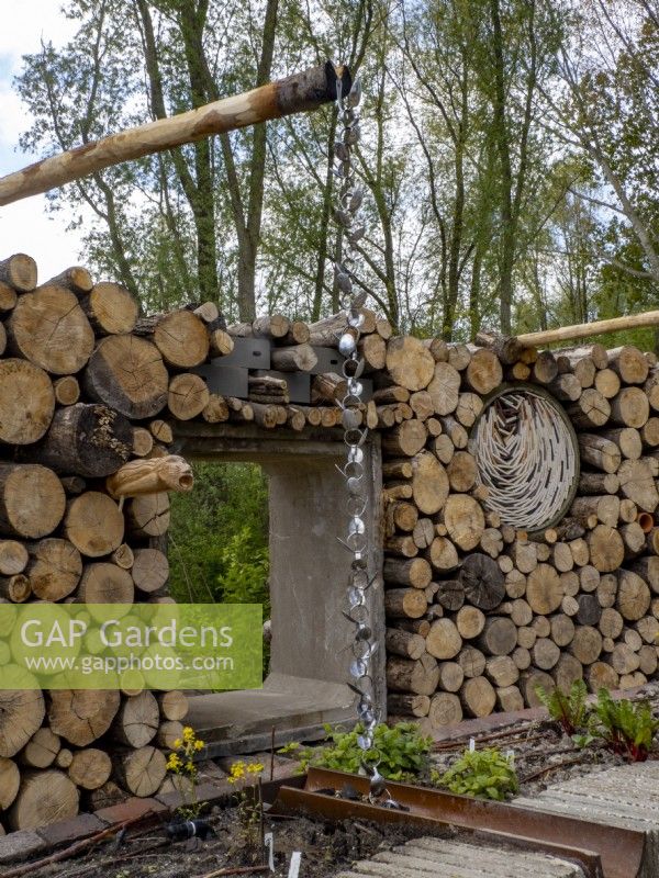 Recycled garden with log wall , rain chain and rusty metal rill pipe. Floriade Expo 2022 International Horticultural Exhibition Almere Netherlands