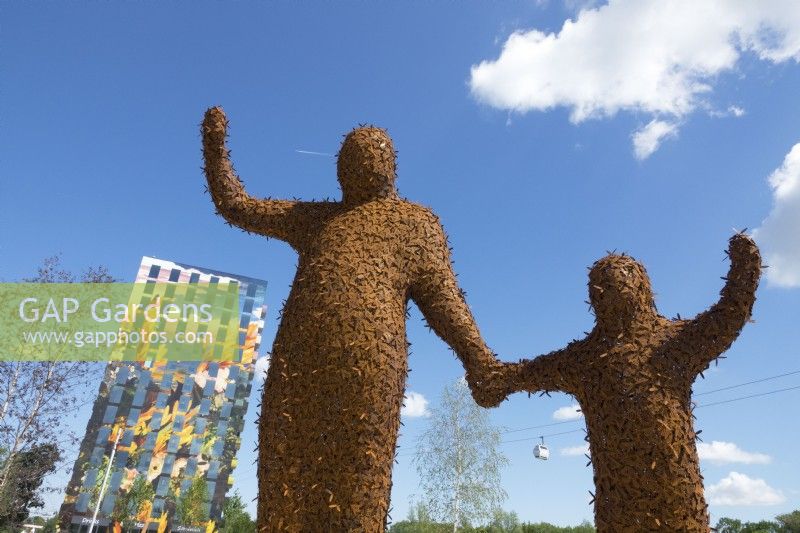 Two giant figures covered with 10,000 bees made of Corten steel designed by Florentijn Hofman named Beehold.