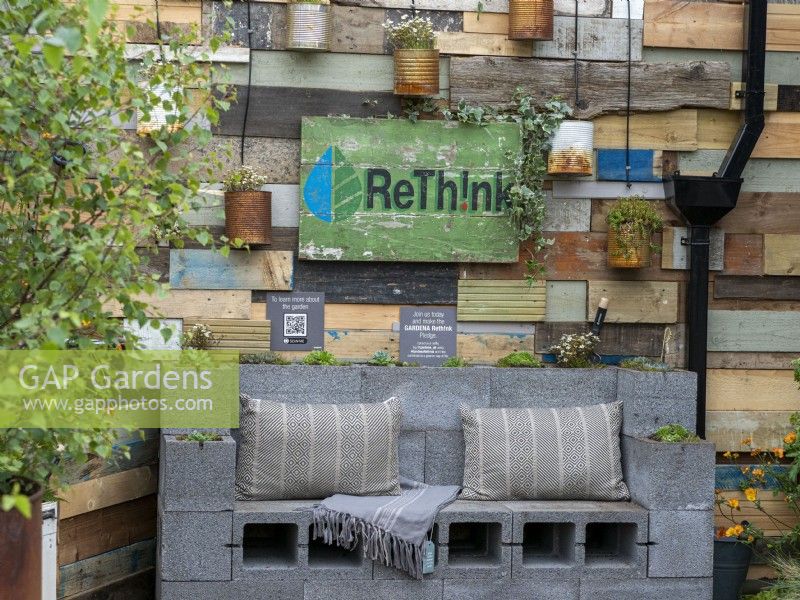 ReThink garden featuring reused items such as cans and wood with seating and a solar watering system
