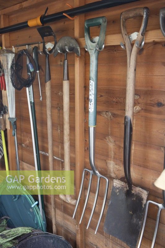 Interior of a well organised garden shed with various tools. Briar Cottage Garden. Devon NGS garden. Spring