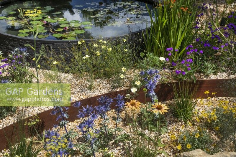 Circular water feature and circular sunken dry bed in the Over The Wall Garden at RHS Hampton Court Palace Garden Festival 2022