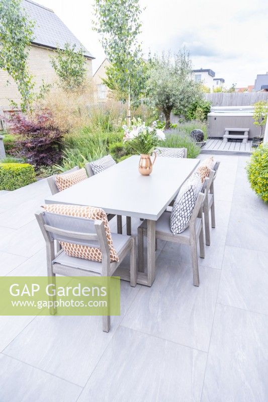 Dining area in front of garden on stone slab patio