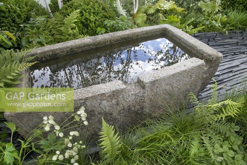 Stone water trough in the Connections garden at RHS Hampton Court Palace Garden Festival 2022