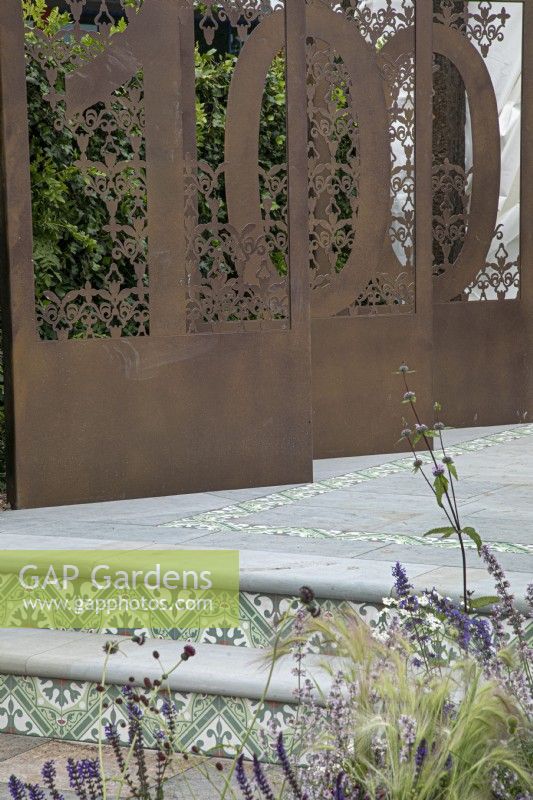 Decorative metal screens depicting the 100 years of the BBC in the Marshalls Landscaping Garden at BBC Gardeners World Live 2022