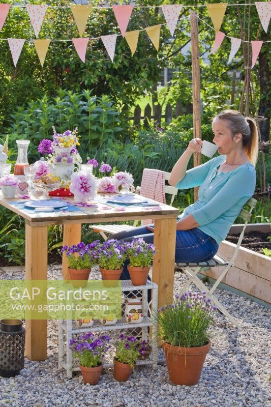 Woman relaxing with cup of tea in the garden.