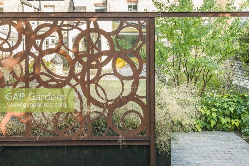 Bespoke corten steel screen in contemporary walled town garden. August