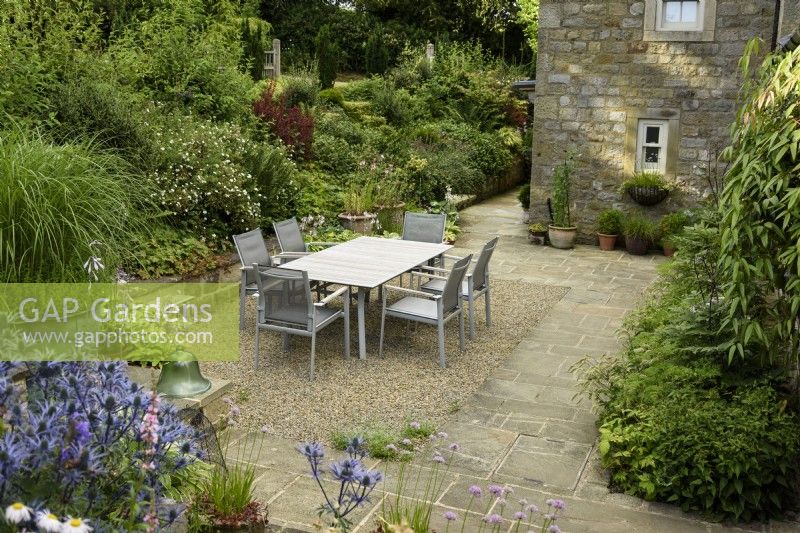 Courtyard garden with dining area at Cow Close Cottage, North Yorkshire in July