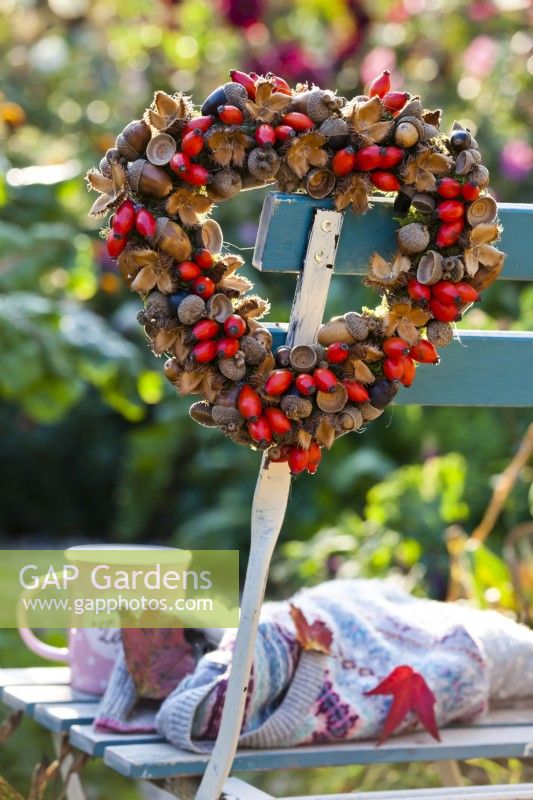 Heart shaped wreath on seat made of rosehips, beechnuts and acorns.