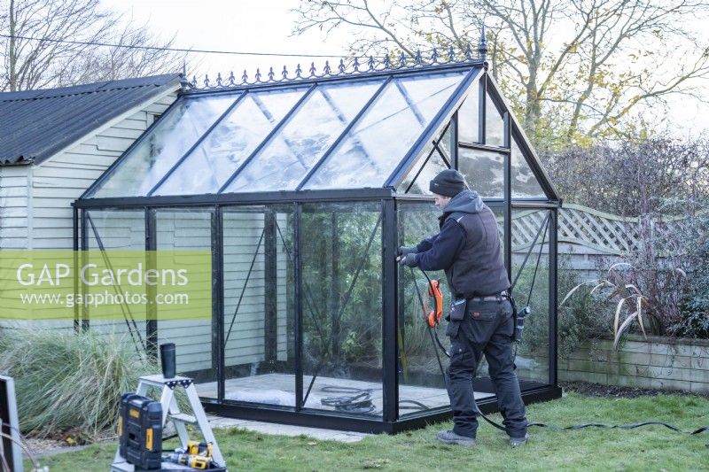 Man placing glass in the greenhouse
