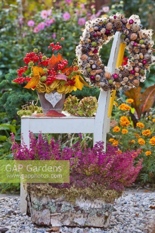 Bark container with heather, autumnal bouquet with leaves and guelder rose berries and wreath.