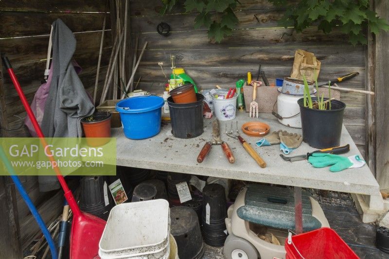 Gardener's work bench with gloves, tools and containers