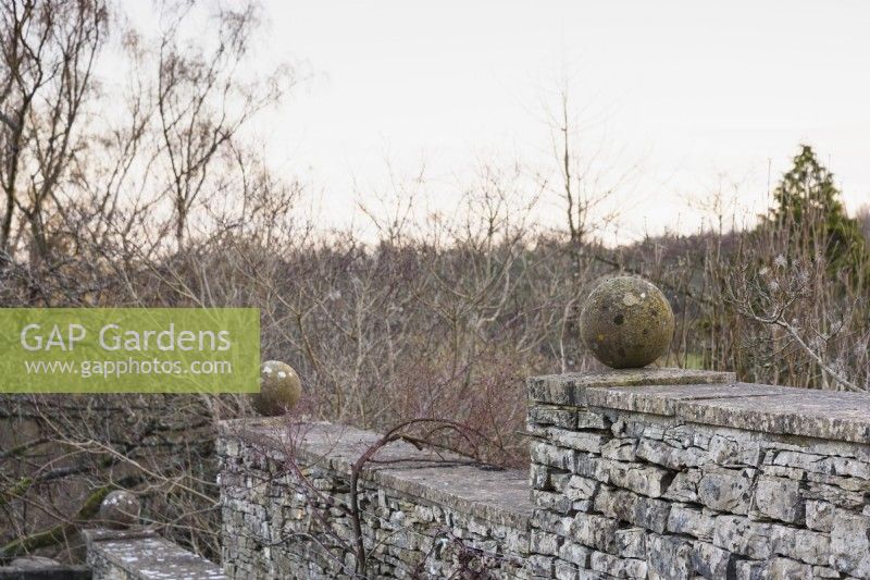 Stone spheres on a wall at Cotswold Farm Gardens in February