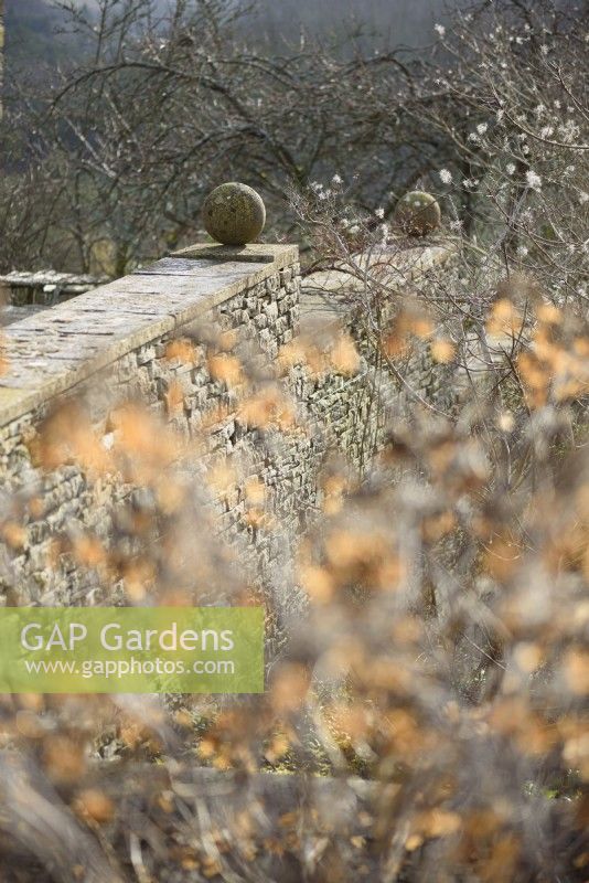 Walls with stone spheres at Cotswold Farm Gardens in February.