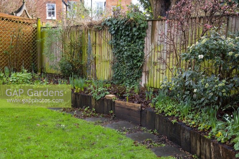 A 'Before' photo of a London garden awaiting a makeover.  Part of the remit was to replace the rotting railroad sleepers and stone path around the raised bed with a brick wall and path.