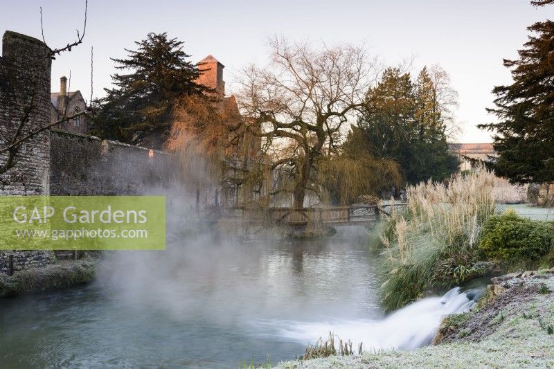 Spring water gushing into the moat on a winter morning at The Bishop's Palace Garden, Wells.