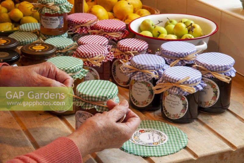 Applying gingham tops to jars of preserves and tying with rafia