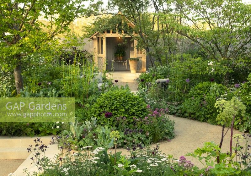 Herbaceous borders surrounding a pegged oak garden room in the RBC Brewin Dolphin Garden designed by Paul Hervey-Brookes at the RHS Chelsea Flower Show 2023.