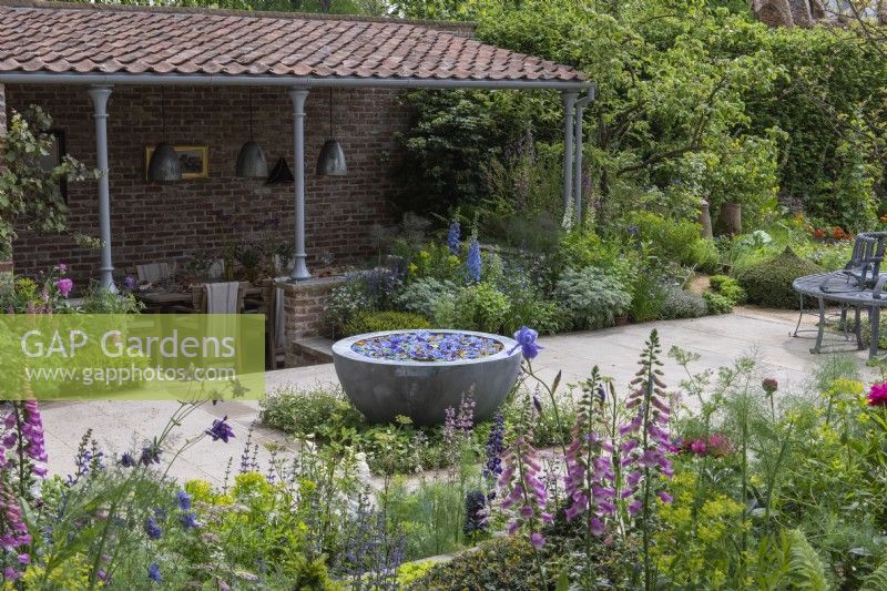 A sunken covered dining area overlooks a seasonal potager filled with ornamental and edible plants, combined in formal or informal schemes, in borders or raised beds.
