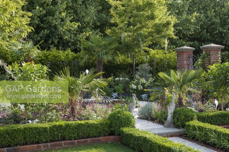 A formal courtyard garden inspired by Charleston, South Carolina, combines palms and exotics with shrub roses, hydrangeas and perennials.