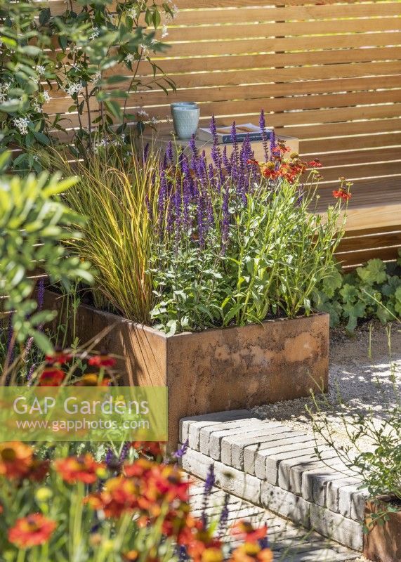 Terrace garden with plant container next to step, summer July