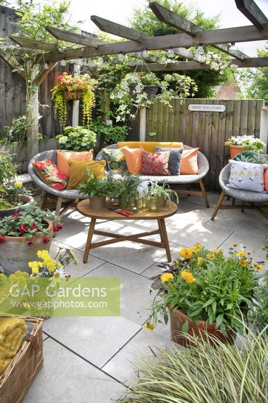 Seating area in small suburban garden in Lichfield, Staffordshire, in red orange and yellow theme, July