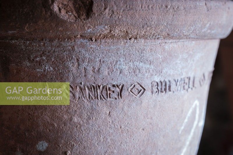 Details of vintage terracotta plant pot showing the makers mark.