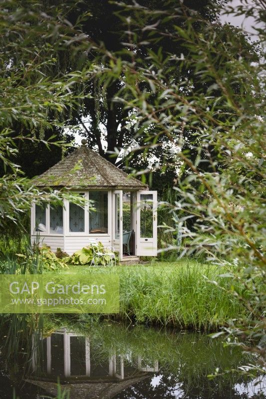Summerhouse on an island in a rural garden in September