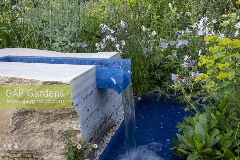 A rill made of recycled plastics surrounded by wildlife friendly planting on the RSPCA Garden designed by Martyn Wilson - RHS Chelsea Flower Show 2023