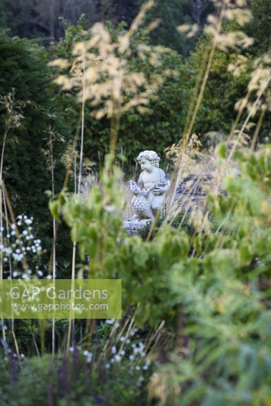 Stone cherub in the walled garden at Parham House in September