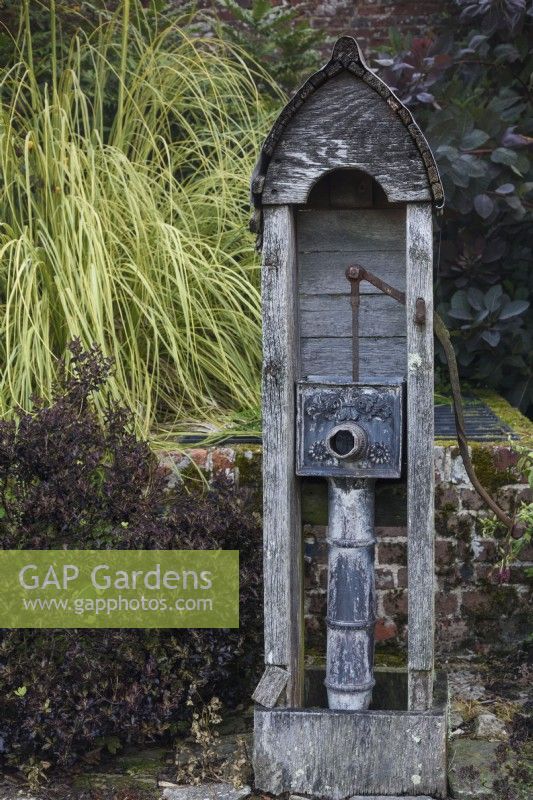 Decorative 1920s water pump in the walled garden at Parham House in September