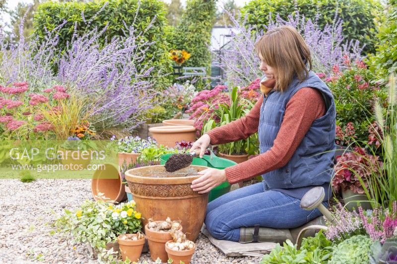 Woman filling container part way with compost