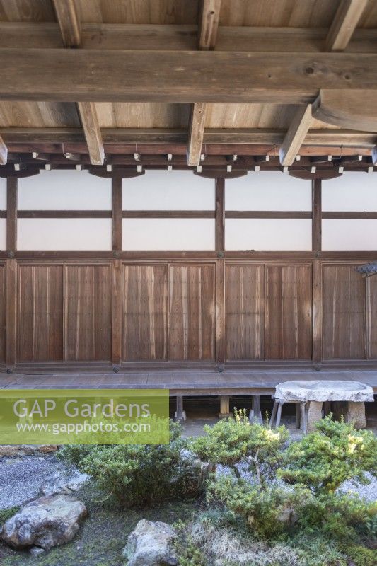 Part of small courtyard garden within temple complex with view to internal covered wooden walkways. 