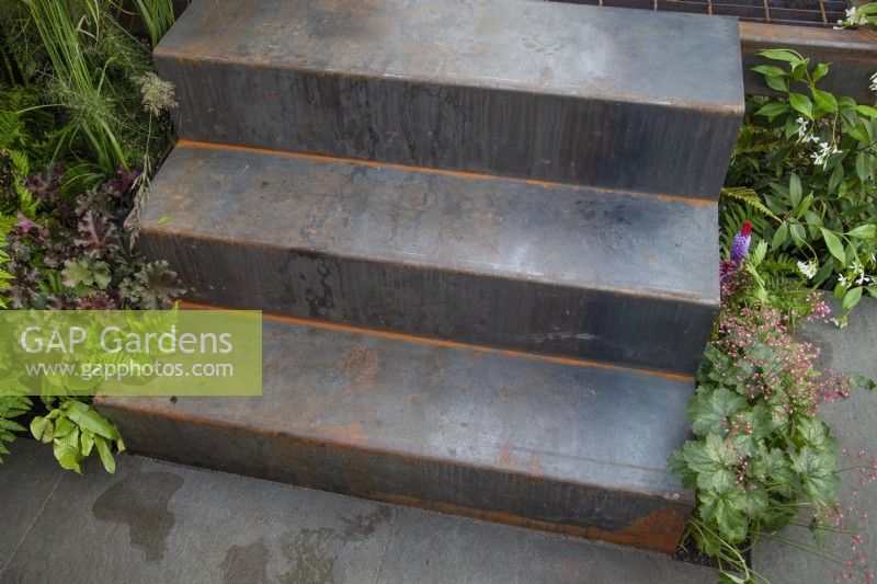 Metal steps in contemporary garden using recycled materials and a dark colour palette - the Hairy Gardener's Garden at BBC Gardener's World Live 2017, June
