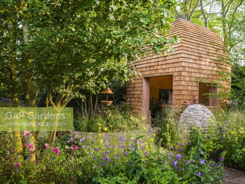 The timber garden room, stone cairns and herbaceous planting beds at Horatio's Garden, Chelsea Flower Show 2023. Designer: Charlotte Harris and Hugo Bugg, Gold medal winner, Best Show Garden