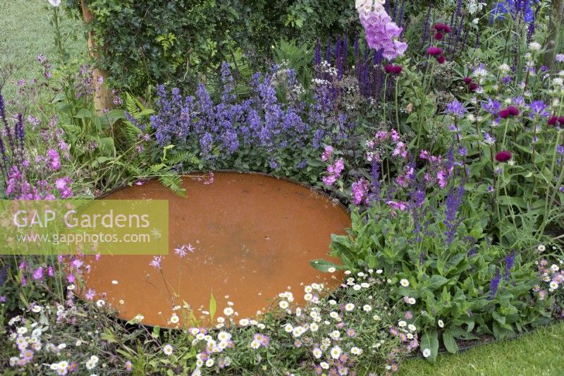Corten steel circular small pond in 'RHS Garden for Wildlife Wild Woven' - RHS Chatsworth Flower Show 2019, June
