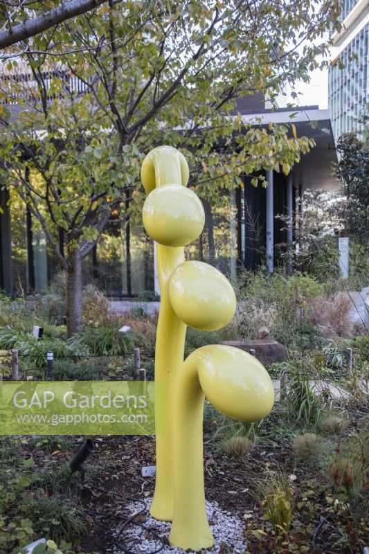 Yellow painted metal abstract sculpture in the Sprouting Garden. 