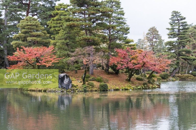View across the Kasumigaike pond to the Horaijima Island. Trees with autumn colour. 