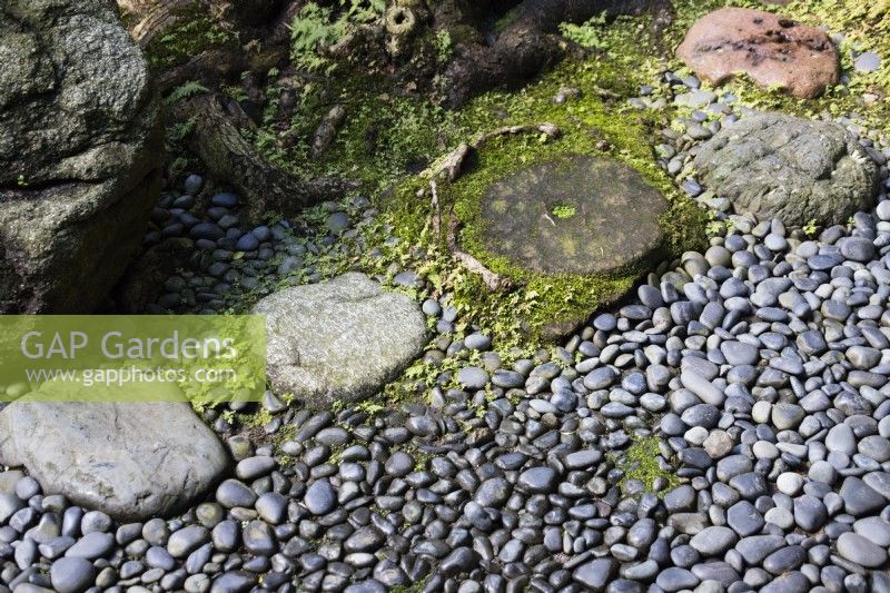 Stone stepping stones next to surface of granite pebbles. 