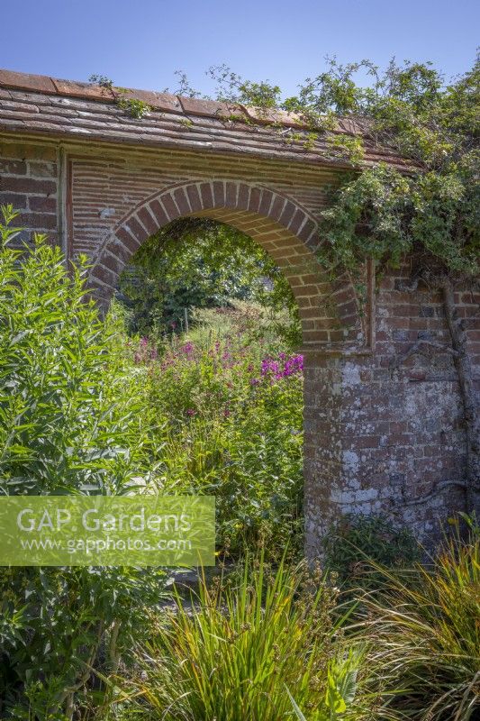 Looking towards the arch from the Mosaic Garden into the Barn Garden at Great Dixter