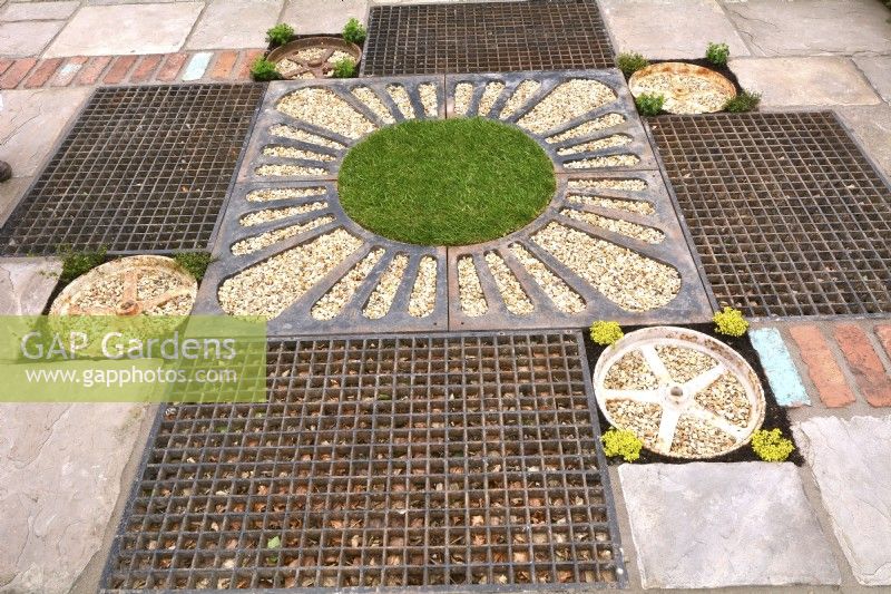 Detail of drainage areas in patio, pathway. Rusty metal grille and gravel drainage with decorative drain covers, rusted drainage, grates water, metal grill in rain garden. April
Designer- Pam Creed