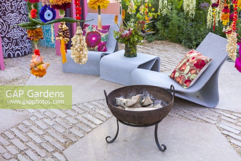 Kadai fire bowl and modern deckchairs and table. The RHS and Eastern Eye Garden of Unity, Designer: Manoj Malde.
