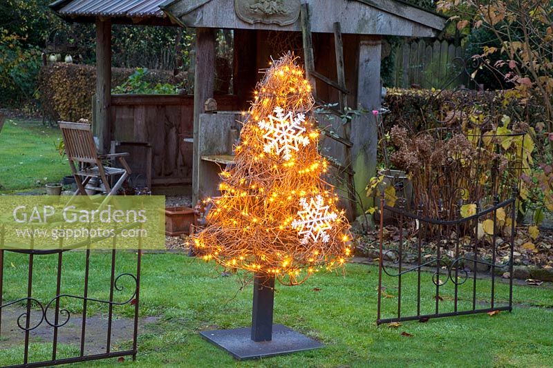 Illuminated Christmas tree made of wooden slats 