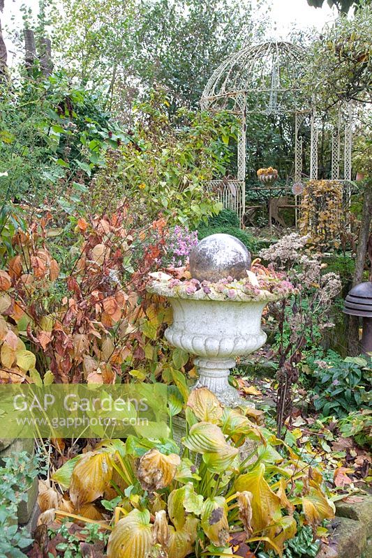 Autumn garden with stone vase and pavilion 
