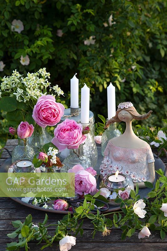 Decoration with girl bust and roses in glass vases 