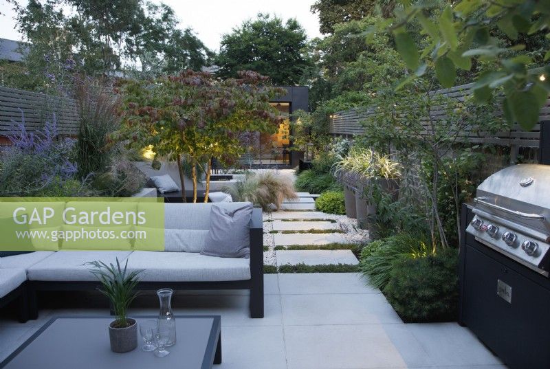 View of the seating area and outdoor kitchen in this city garden which can be used day or night thanks to the outdoor lighting